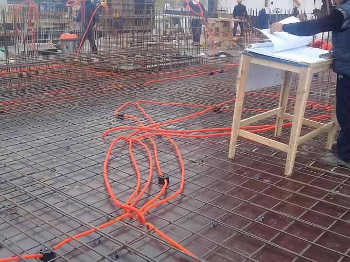 Canalización naranja sobre malla de hierro en una losa