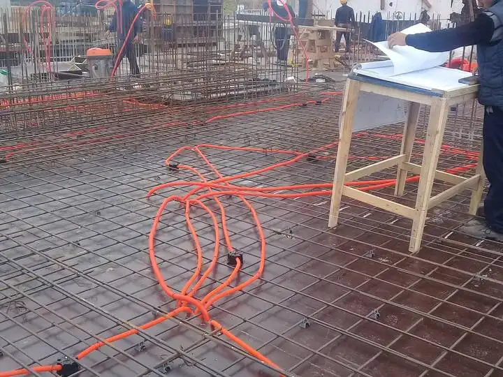 Canalización naranja sobre malla de hierro en una losa