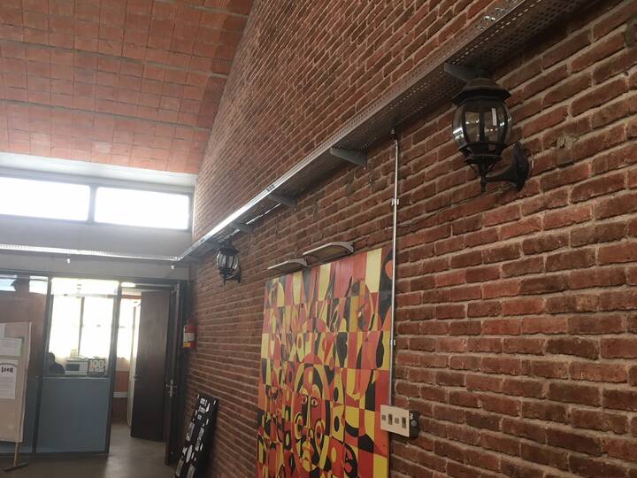 Sala blanca con tablero de sector y canalización a la vista